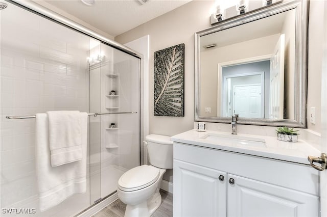 bathroom with walk in shower, vanity, toilet, and wood-type flooring