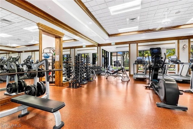 workout area with a drop ceiling, crown molding, and a raised ceiling