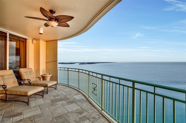 balcony with a water view and ceiling fan