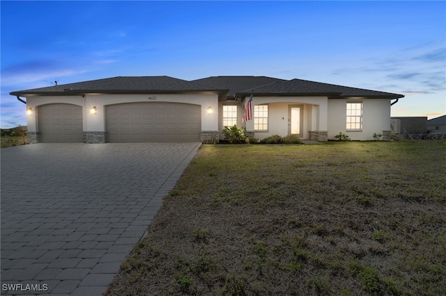 view of front of property with a garage and a lawn