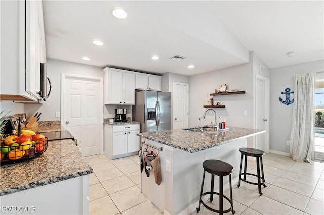 kitchen with white cabinetry, stainless steel appliances, sink, and a kitchen island with sink