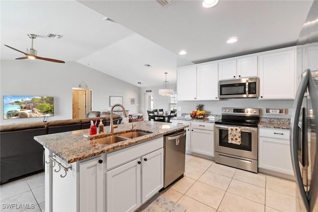 kitchen with sink, white cabinetry, hanging light fixtures, stainless steel appliances, and an island with sink