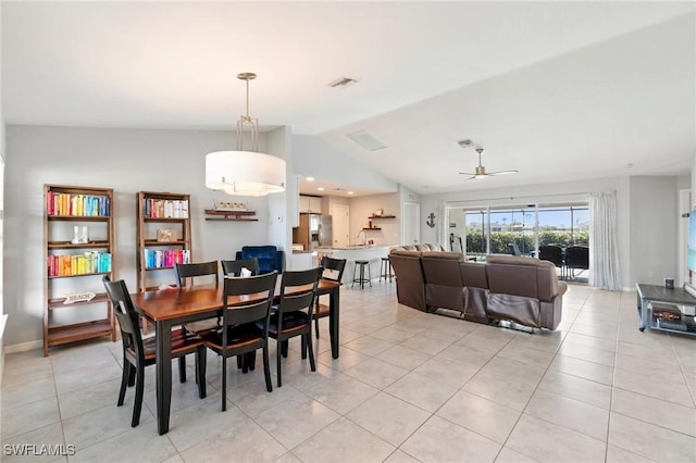 dining room with ceiling fan, lofted ceiling, and light tile patterned floors