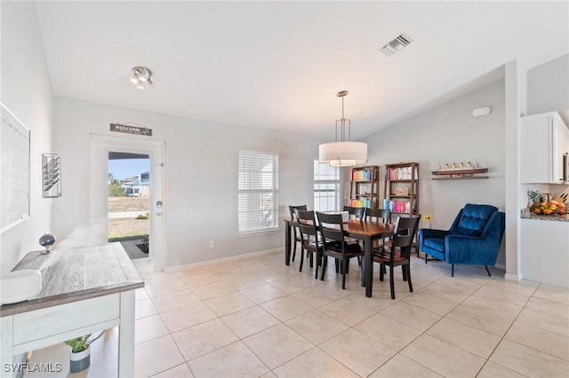 dining area with vaulted ceiling and light tile patterned flooring