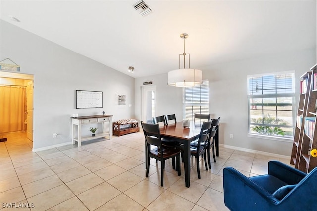 tiled dining room featuring vaulted ceiling