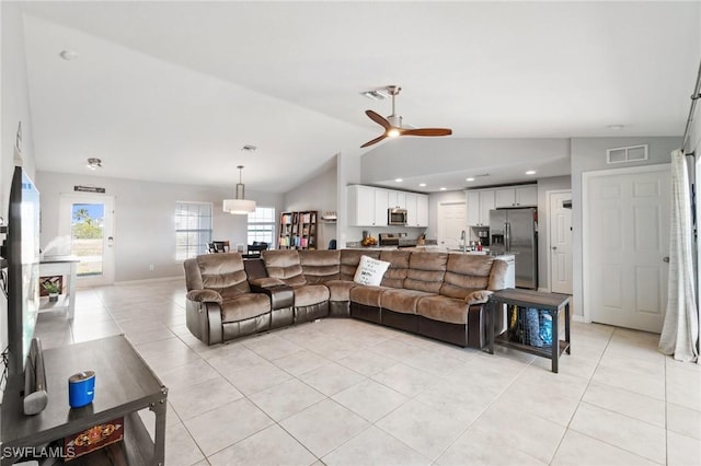 living room with light tile patterned floors, vaulted ceiling, and ceiling fan