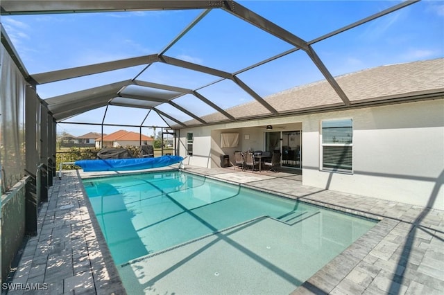 view of pool with a patio area, ceiling fan, and glass enclosure