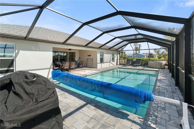 view of pool with a hot tub, a patio, a lanai, and ceiling fan