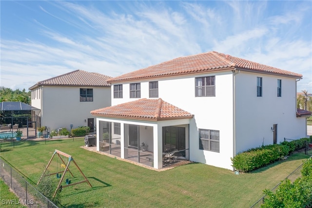 back of property with a lawn and a sunroom