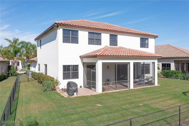 rear view of property with a yard, a sunroom, and a patio