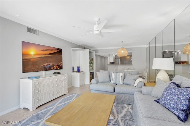 living room with crown molding, ceiling fan, and light tile patterned flooring