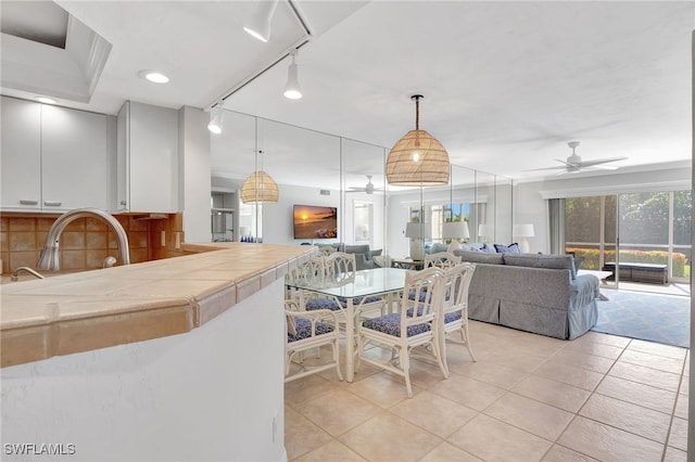 dining area featuring ceiling fan, track lighting, and light tile patterned floors