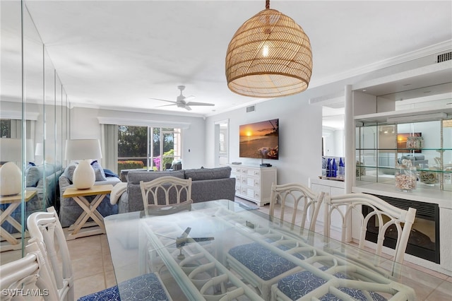 dining room with crown molding, ceiling fan, and light tile patterned floors