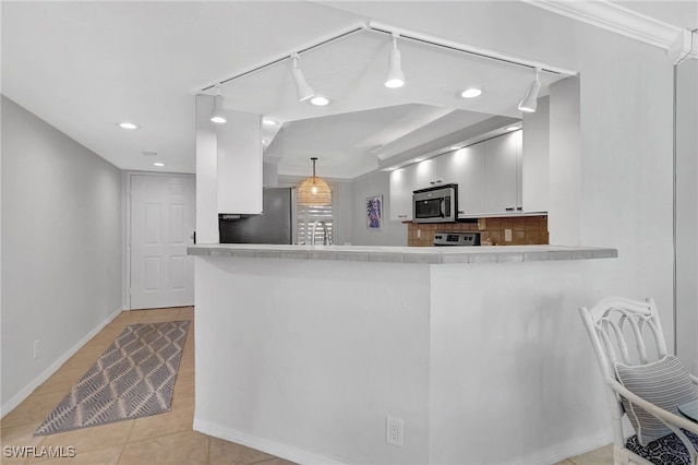 kitchen with pendant lighting, light tile patterned floors, appliances with stainless steel finishes, white cabinets, and kitchen peninsula