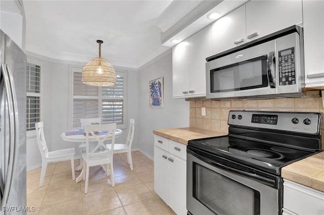 kitchen featuring decorative light fixtures, ornamental molding, appliances with stainless steel finishes, decorative backsplash, and white cabinets