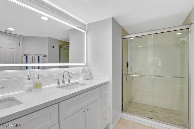 bathroom featuring vanity, backsplash, and walk in shower