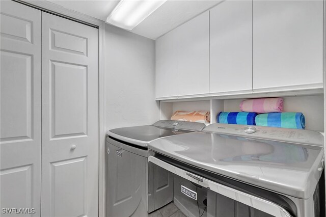 laundry area featuring washing machine and dryer and cabinets