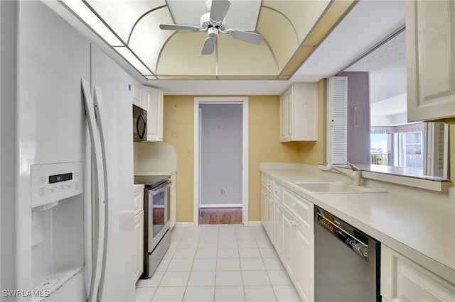 kitchen with stainless steel appliances, white cabinetry, sink, and light tile patterned floors