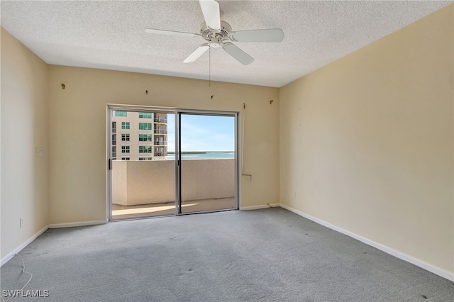 carpeted spare room with ceiling fan and a textured ceiling