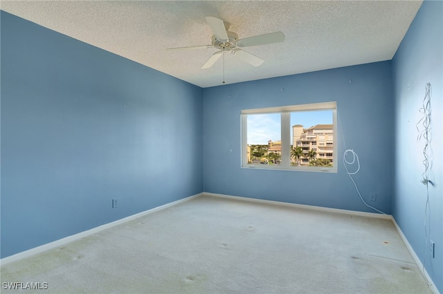 carpeted empty room with a textured ceiling and ceiling fan