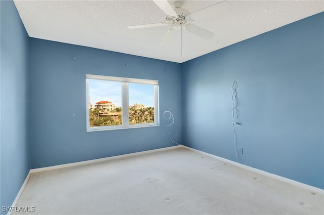 carpeted spare room with ceiling fan and a textured ceiling