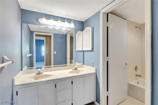 bathroom with tiled shower / bath combo, vanity, and tile patterned floors