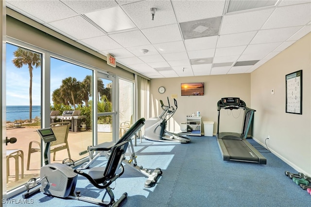 exercise area featuring a water view and a paneled ceiling