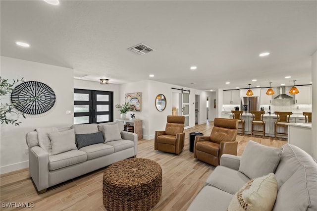 living room with light hardwood / wood-style floors and a barn door