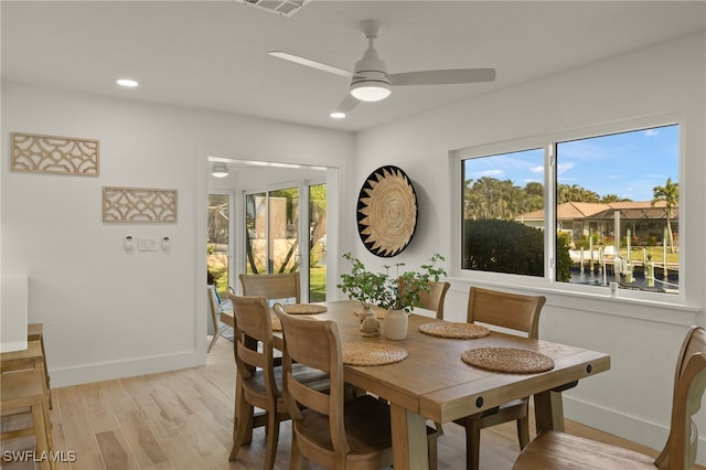 dining area with light wood-type flooring and ceiling fan