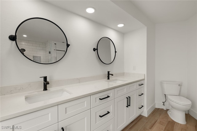 bathroom with hardwood / wood-style flooring, toilet, and vanity