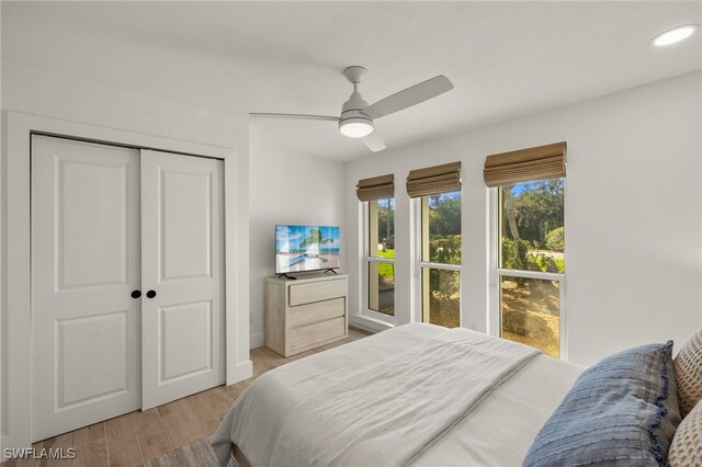 bedroom featuring ceiling fan, light wood-type flooring, and a closet