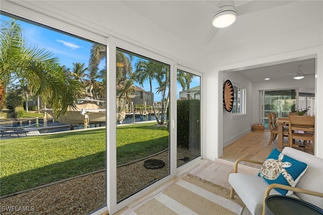 unfurnished sunroom with a water view and ceiling fan