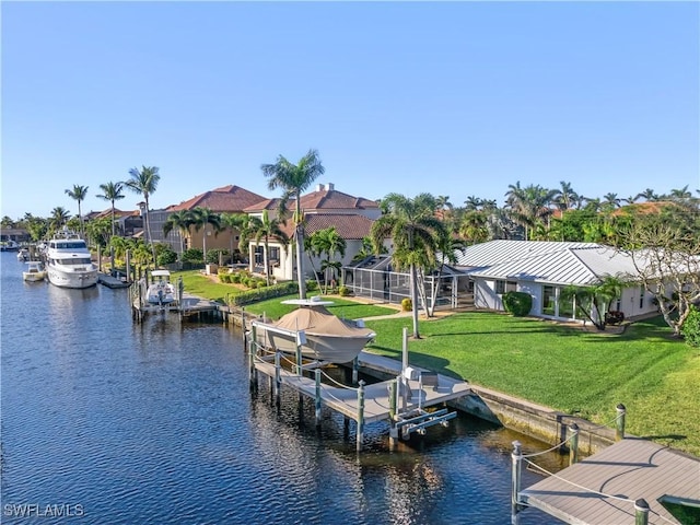 view of dock featuring a water view, glass enclosure, and a lawn