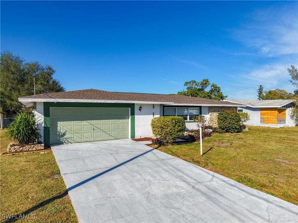 ranch-style house featuring a garage and a front yard