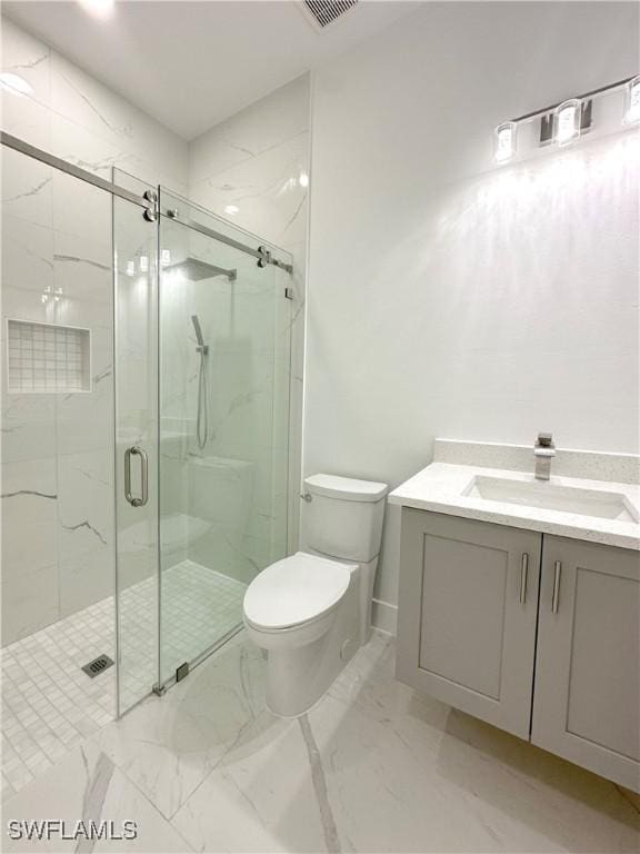 bathroom featuring vanity, a shower with shower door, and toilet