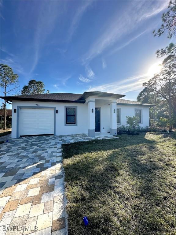 ranch-style house featuring a garage and a front lawn