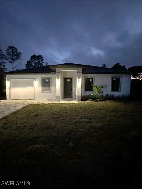 view of front of house with a garage and a front lawn