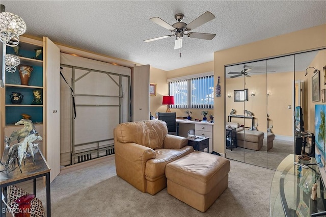 living area featuring a textured ceiling, ceiling fan, and carpet flooring