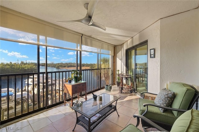 sunroom with a water view and a ceiling fan