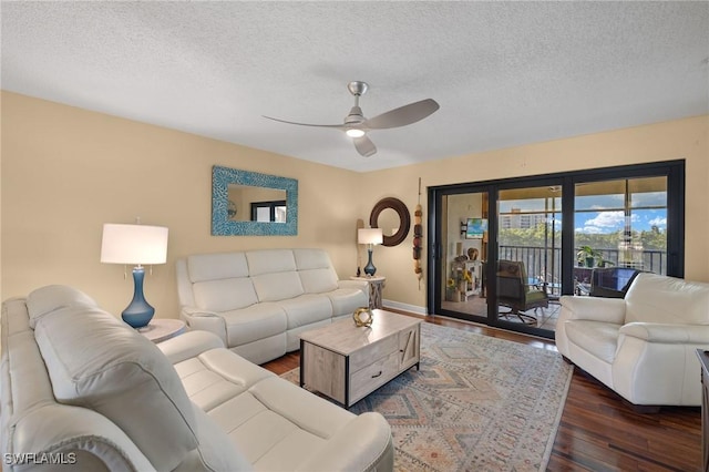 living area with dark wood finished floors, a textured ceiling, and ceiling fan