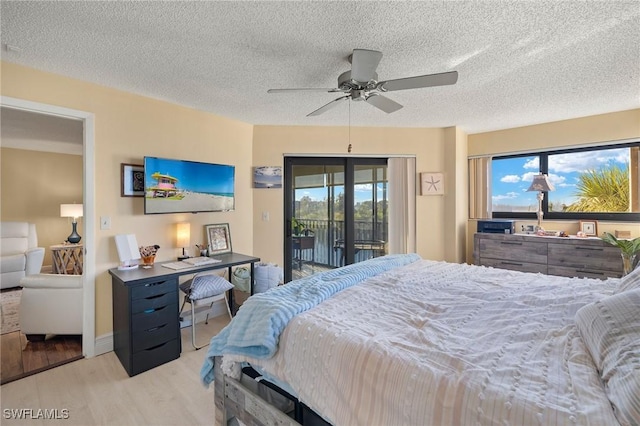 bedroom featuring access to exterior, ceiling fan, a textured ceiling, and wood finished floors