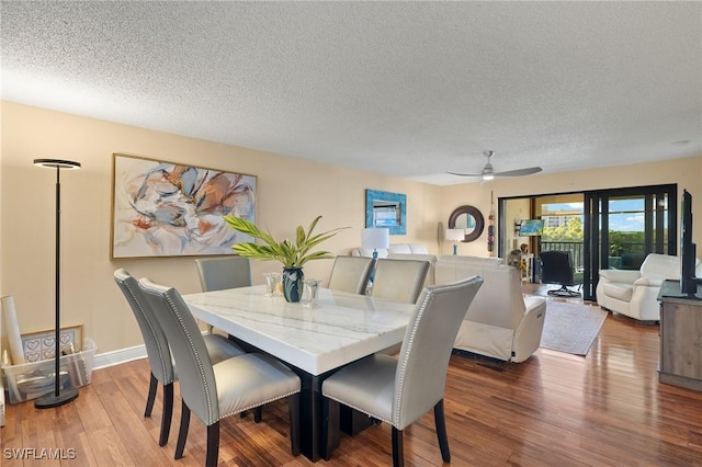 dining space with a textured ceiling and wood finished floors