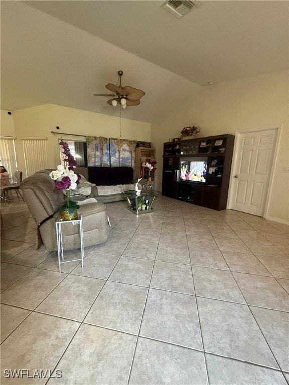 unfurnished living room with ceiling fan, light tile patterned floors, and vaulted ceiling