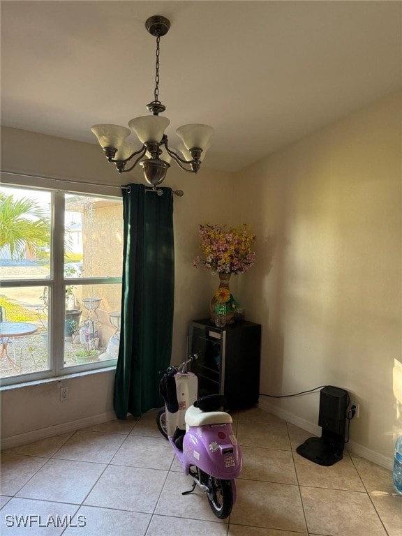 dining space with light tile patterned flooring and an inviting chandelier