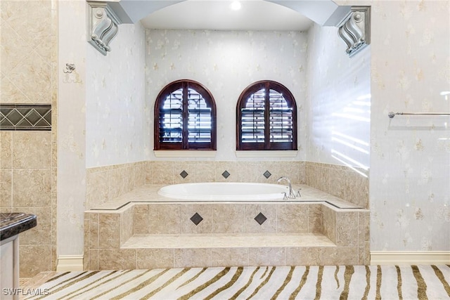 bathroom with vanity and tiled tub