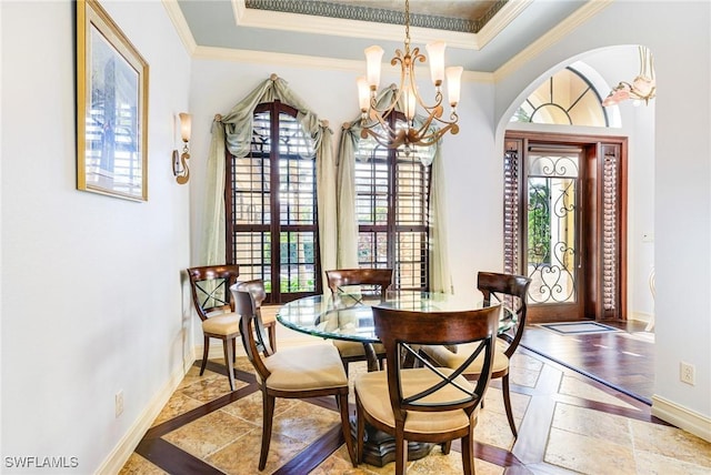 dining area featuring crown molding, a chandelier, and a tray ceiling