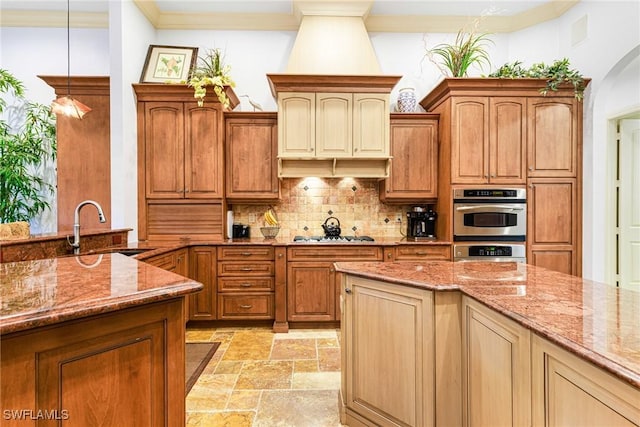kitchen with sink, light stone countertops, hanging light fixtures, and stainless steel oven