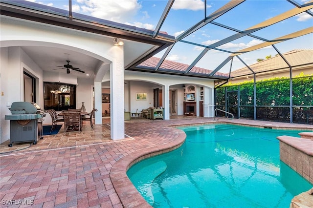 view of pool featuring ceiling fan, a lanai, area for grilling, and a patio area