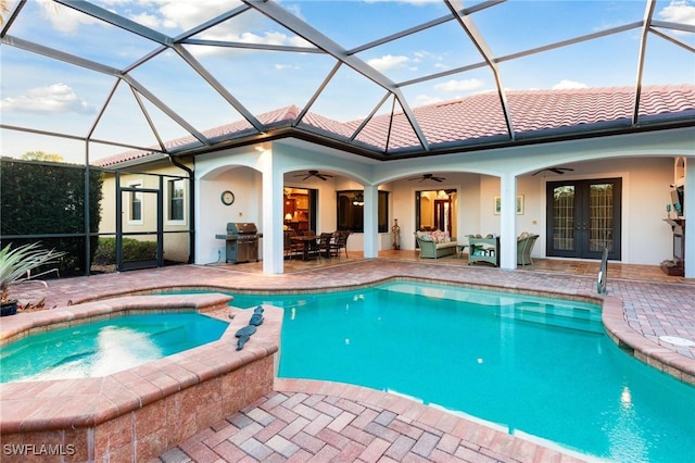 view of swimming pool featuring an in ground hot tub, ceiling fan, glass enclosure, and french doors