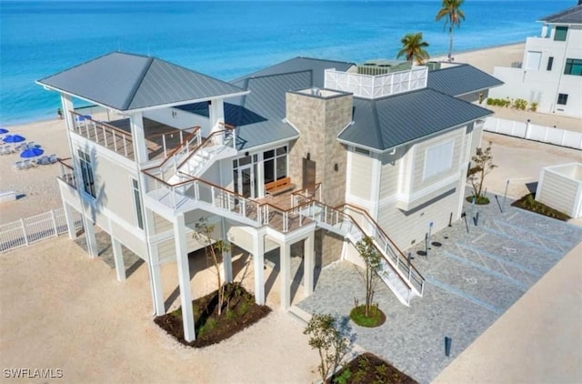 drone / aerial view featuring a water view and a beach view